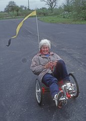 Frau Reitliegende Dreirad auf der Straße UK reitet
