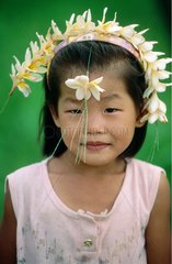 Petite fille avec une couronne de fleurs de frangipaniers