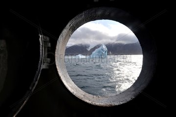 Iceberg drift seen through the porthole of a ship Canada