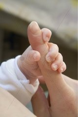 Petite main de bébé tenant le doigt de sa mère