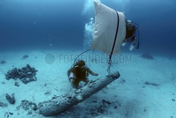 Lifting a cannon during the recovery of a shipwreck Bahamas