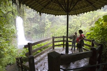 Tourists observing a waterfall from a panormaic viewpoint