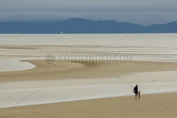 Father and son walking over tidal flats of the Oak beach