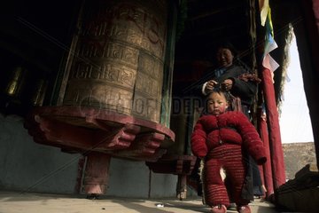 Tibetan child and his grandmother in a Buddhist temple