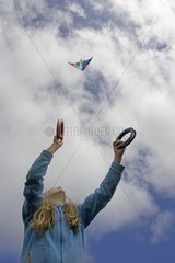 Girl flying kite on an cliff England