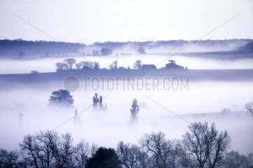 Ferme de Salles émergeant du brouillard au petit matin Gers