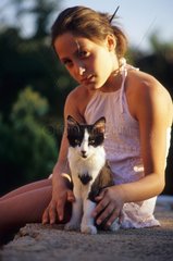 Girl and male kitten on a low wall France