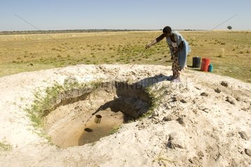 Woman drawing water for the village Botswana