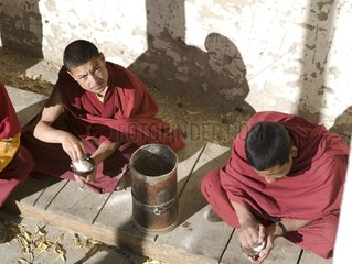 Monks taking their breakfast with the tsampa Ladakh India