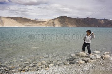 Boy on the shore of Lake Pangong Ladakh Himalaya India
