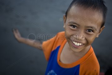 Portrait of smiling boy on a black sand beach Bali