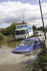 Vehicles partly submerged on a flooded road UK
