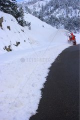 Schneepflugmaschinenreinigen ein schneebedeckter Straßenaran -Tal