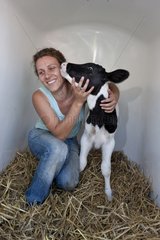 Eine Frau  die sich um eine Nische -Kalbfänger -Holstein -Deutschland kümmert