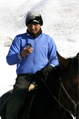 Young nomad sending SMS Son Kul Lake Kirghizistan