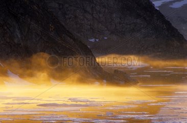 Brumes orangées sur la banquise Fjord Groenland
