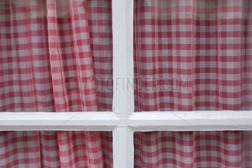 Fenster und Vorhang mit roten Quadraten im Baskenland