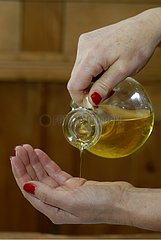 Olive oil flowing in one hand to treat skin