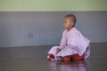 Nun sitting before a meditation session Burma