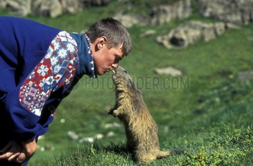 Homme jouant avec une Marmotte des Alpes PN Vanoise France