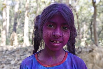 Girl with the face colored by powders during a holy festival