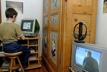 Boy playing computer and television on