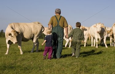 Bauer beobachtet sein Vieh mit seinen Enkelkindern Frankreich
