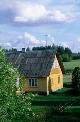 Maison en bois jaune dans la campagne lettone.