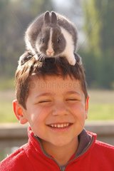 Enfant portant un lapin sur sa tête
