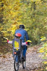 Mädchen im Rücken eines Fahrrads in einem Waldweg Frankreich