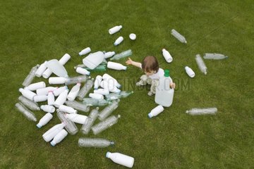 Child playing with plastic bottles in grass