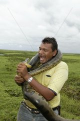 Homme Imitant l'Anaconda qu'il A Autour du Cou Venezuela