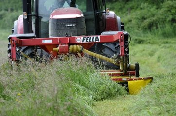 Tractor mowing a meadow in spring Doubs France
