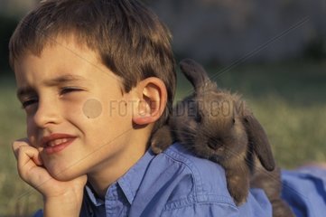 Rabbit dwarf ram on the shoulders of a boy