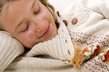 Girl with an outgoing gilded hamster of the collar of its sweater