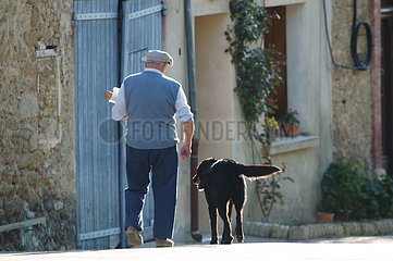 A man and its dog coming back of bakery France