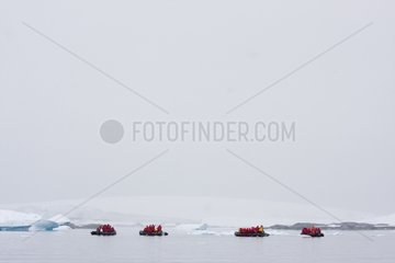 Touristen in aufblasbaren Booten neben einer Eisberg -Antarktis