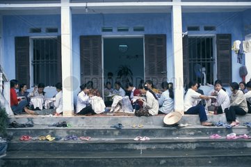 Frauen  die vor einem Haus sitzen und Vietnam sticken