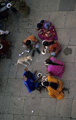 Women eating in the street and dog Vârânaçî India