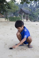 Boy playing with Urchin Archipelago Bacuit El Nido Palawan
