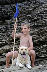 Boy and his Labrador dog on the rocks Britain France
