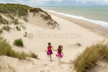 Little girls running in the dunes of the Opal Coast  summer  Pas de Calais  France