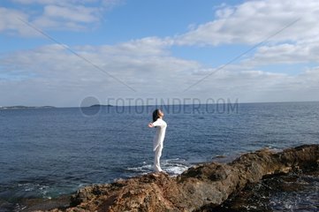 Femme s'étirant et respirant l'air de la mer
