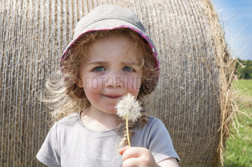 Girl blowing on a seed dandelion
