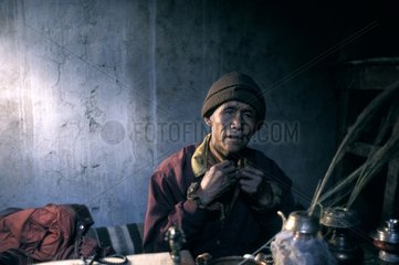 Mann  der in seinem Haus Mustang Nepal sitzt