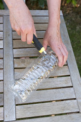 Realization of a slug trap with metaldehyde granules. Place the toxic pellets for wildlife in a plastic bottle cut in half  only the slugs will have access to the poison.