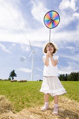 Little girl playing with a reel on a haystack France