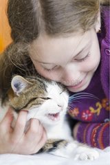 Ten year old girl hugging her cat