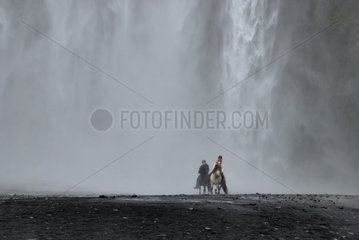 Riders under the waterfal of Seljalandsfoss in Iceland