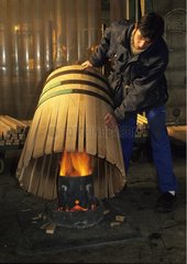 Manufacturing barrels by heating and wood strapping
